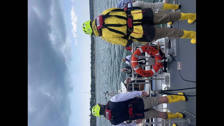 Two crew members onboard looking out at sea at laying of the wreath