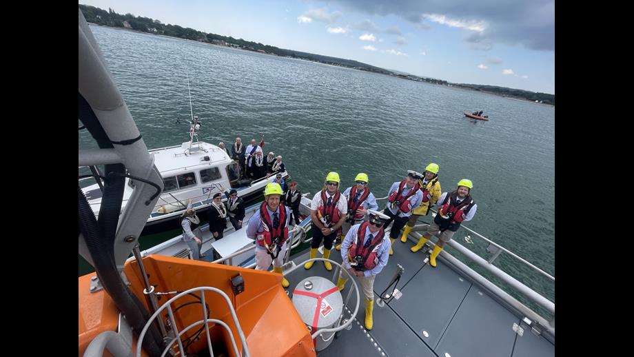 Birds-eye view of the crew and a smaller boat along-side, group photo 