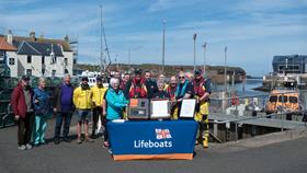 Eyemouth RNLI fundraisers and crew gathered at Eyemouth harbour to sign the historic scroll