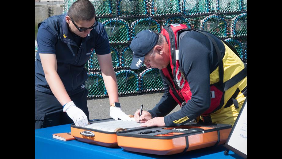 Peter Walker, of Eyemouth RNLI crew, signs the 'Connecting our Communities' scroll
