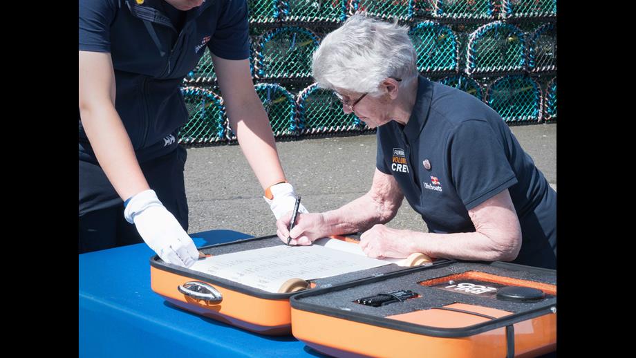 Margaret Driscoll, of RNLI Burnmouth &amp; Eyemouth Fundraising Group, signs the 'Connecting our Communities' scroll