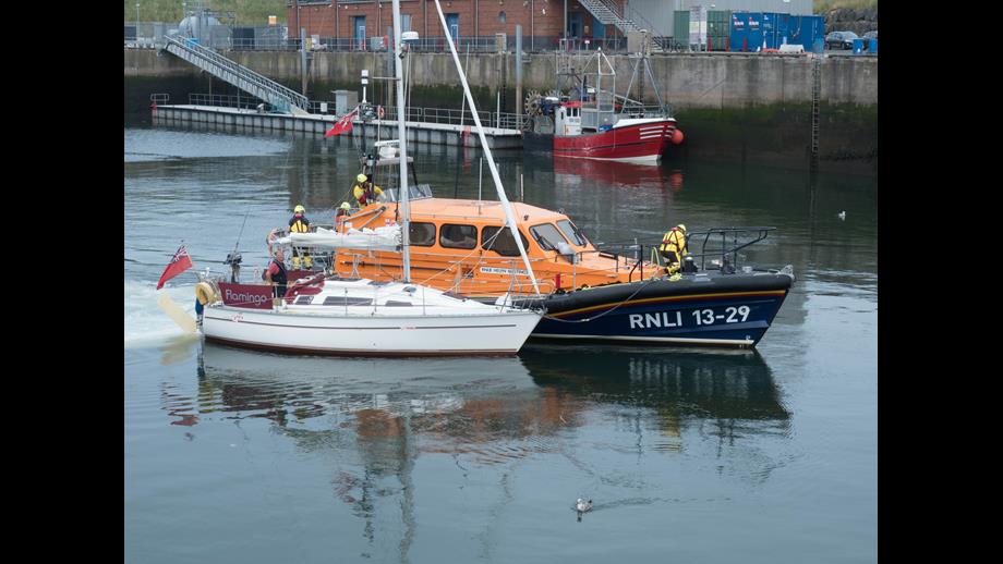 Eyemouth Shannon class all-weather lifeboat tows casualty yacht 'Flamingo' into Eyemouth harbour
