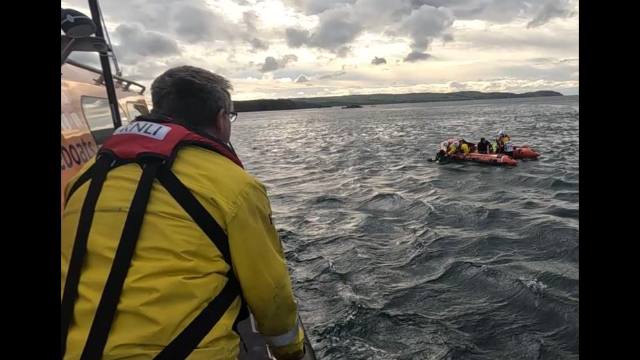 Two divers are helped aboard Eyemouth RNLI inshore lifeboat, watched over by volunteers on the all-weather lifeboat