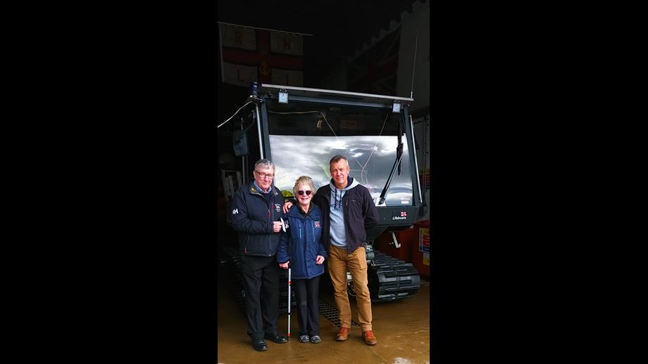 George Craig stood with his wife and son in front of lifeboat tractor