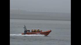 New Brighton RNLI's Atlantic-85 lifeboat is seen travelling at speed on a foggy river.
