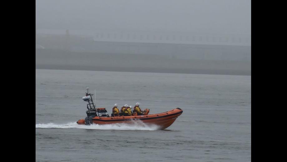 New Brighton RNLI's Atlantic-85 lifeboat is seen travelling at speed on a foggy river.