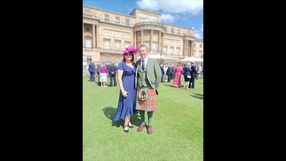 Couple standing on the lawn at Buckingham Palace