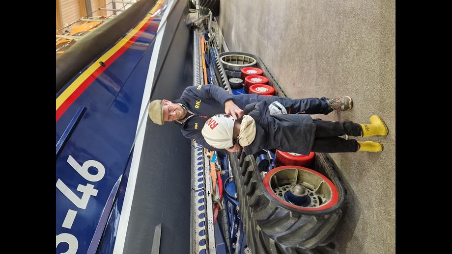 Young lad and man in front of shannon class lifeboat