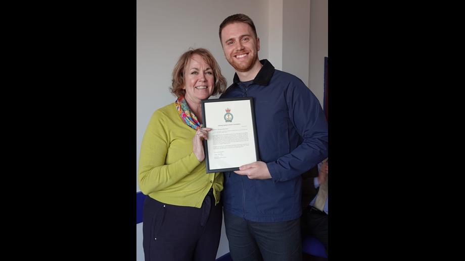 Jayne hands Miles a certificate of commendation 