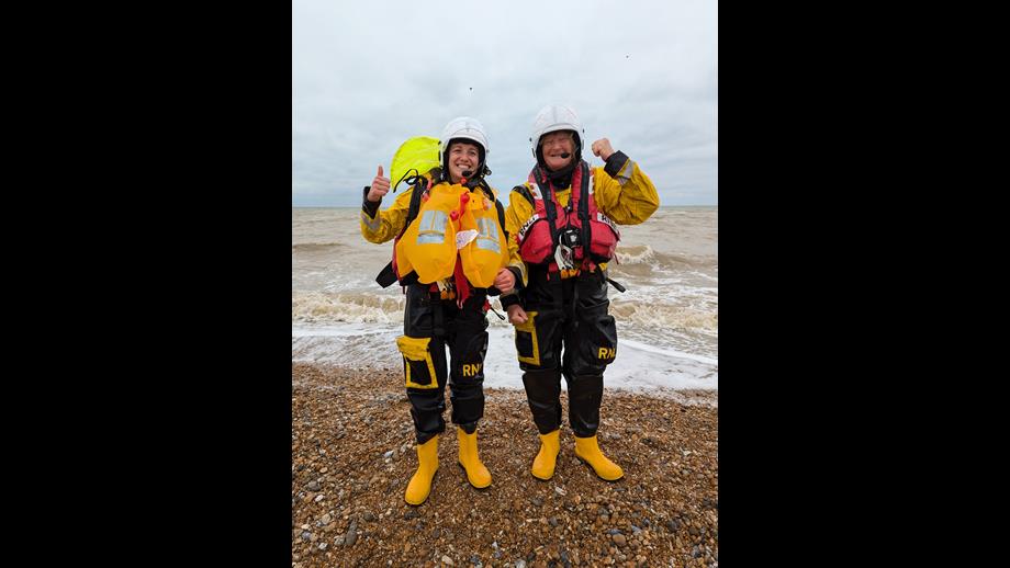 Mihaela and Sarah from Littlestone RNLI in full yellow and black RNLI drysuits giving the thumbs up after their successful trips afloat
