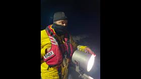 Crew members looking for debris etc with searchlights in use.
