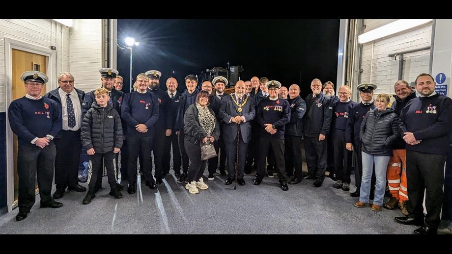 RNLI volunteers and families infront of the RNLI tractor and lifeboat with Lord Warden Admiral Sir George Zambellas and The Right Worshipful the Mayor of New Romney CllrJohn Rivers after receiving their King's Coronation Medals