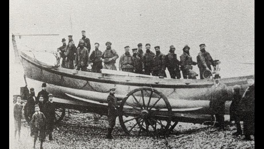 A black and white photo of an open rowing boat as used in the 1890's