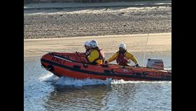 Wells RNLI inshore lifeboat launches to assist two people cut off by the tide. Crew of three volunteers on board.
