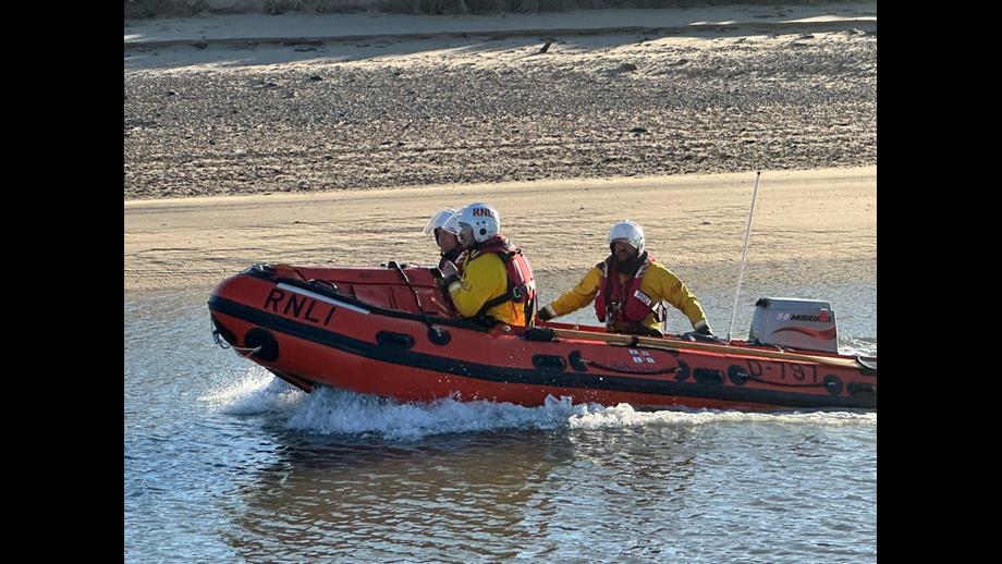 Wells RNLI inshore lifeboat launches to assist two people cut off by the tide. Crew of three volunteers on board.
