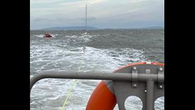 Barry Dock RNLI lifeboat towing yacht towards Porthcawl in rough seas 