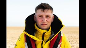A crew member in RNLI yellow jacket looks at the camera