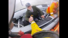 Allan being taken by the hand of lifeboat crew Simon Johnson from powerboat Salty Sea Dog