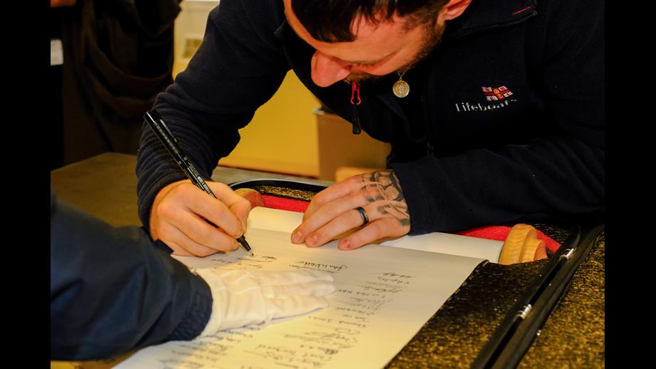Stephen Manson, RNLI Lerwick Coxswain signs the RNLI 200 Scroll. 