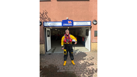 Volunteer crew member stands in front of Teddington RNLI lifeboat station