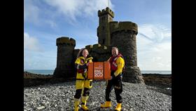 Douglas RNLI volunteer Coxswain, Emily Heaton and Port Erin Mechanic Jason Fleming with the scroll at the Tower of Refuge