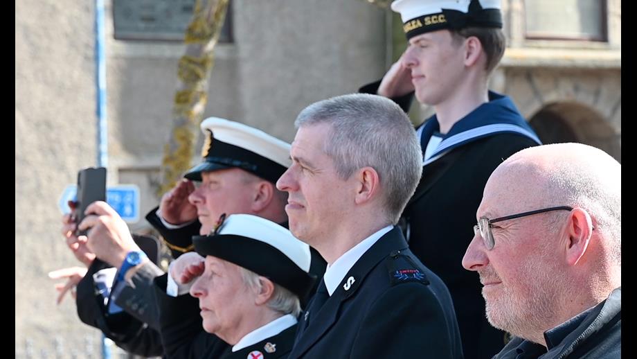 Fraserburgh RNLI Coxswain Vic Sutherland and other attendees reflect on the many courageous men and women who serve or have served as merchant seafarers, as the Red Ensign is raised.