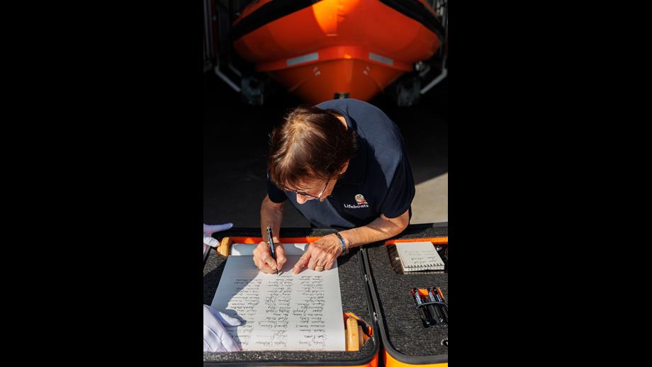 Marian Kennedy signing the scroll
