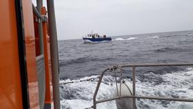 Eyemouth lifeboat crew assist injured angler on fishing trip, view is from the lifeboat looking across to the fishing boat where lifeboat crew gave first aid casualty care.