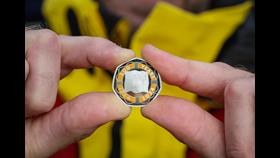 Close up of hands holding The Royal Mint commemorative RNLI 200 50p coin