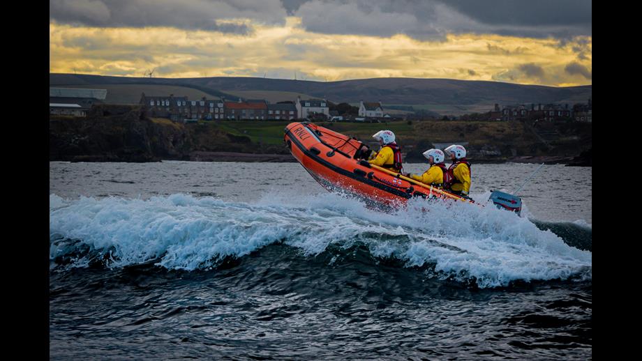 Rigid inflatable lifeboat on water.