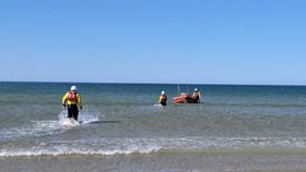 RNLI crew leaving the beach after rescuing casualty