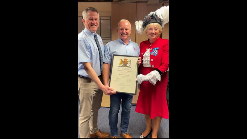 Portrait view of Mike being presented with long service award by the High Sheriff and LOM
