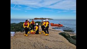 RNLI crew can be seen performing first aid training with the D class in the background