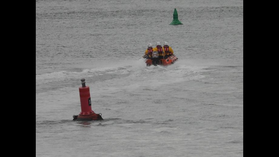 Wells RNLI inshore lifeboat Peter Wilcox launched to cut off by the tide three volunteers onboard in full RNLI inshore kit
