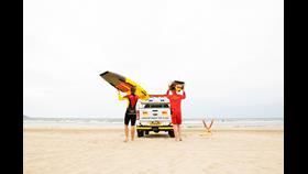 Lifeguards on Duty on a beach in Northern Ireland. Placing boards on the back of their truck
