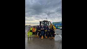 A group of New Brighton's volunteer crew stand posed proudly in front of the tractor.
