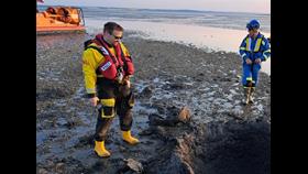 Southend RNLI and Coastguards examine the result of the controlled detonation, Southend RNLI hovercraft in background and 4 foot crater from detonation in the foreground
