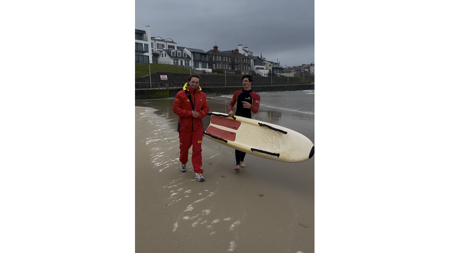 RNLI lifeguards Cameron Leighton &amp; Ethan Hill returning from the sea after assisting five children caught by offshore winds, out at sea
