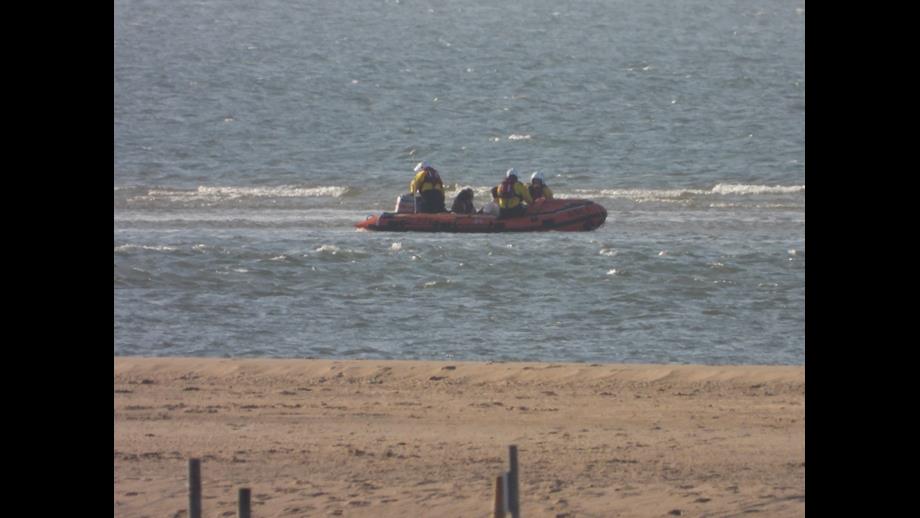 Wells RNLI Assist four cut off on sand bar Wells Beach. Lifeboat and volunteer of three assisting people cut off by the tide