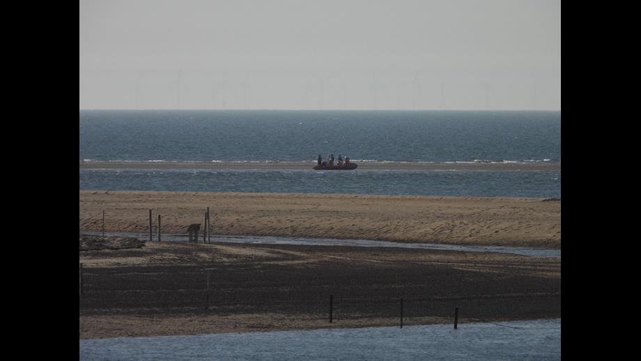 Wells RNLI Assist four cut off on sand bar Wells Beach Lifeboat and volunteer of three assisting people cut off by the tide