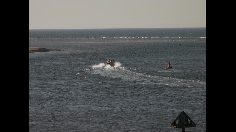 Wells RNLI Inshore Lifeboat Peter Wilcox assist four cut off by the tide. Inshore lifeboat heading out to sea with a crew of three