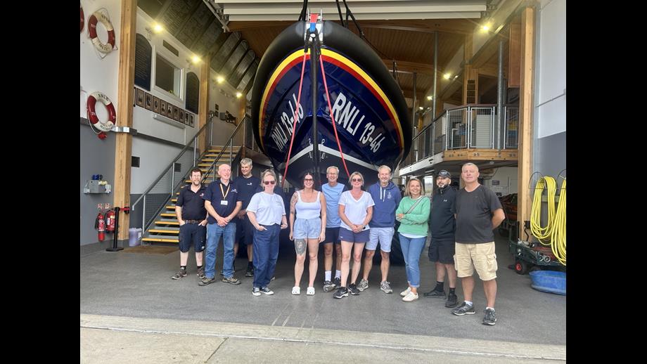BM Solutions team roll up their sleeves to support Wells RNLI members of BM solutions and Wells RNLI in front of Shannon class lifeboat