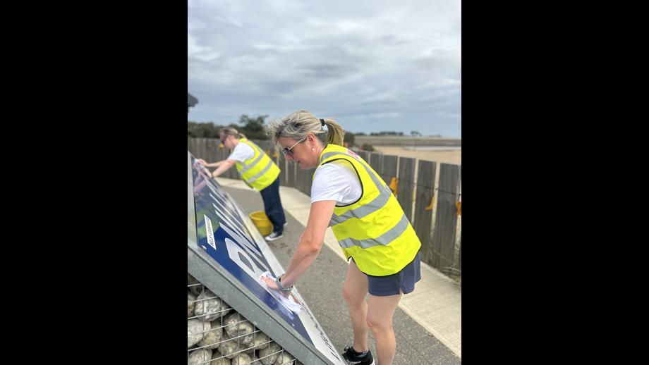 Members of BM Solutions team posing in Hi-Viz tabards with tools and cleaning materials