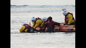 Wells Lifeguards join Wells RNLI D-class lifeboat on training exercise. Two lifeguards join a volunteer lifeboat crew of four on a training exercise. Lifeboat crew practising how to best mauver casualty onto lifeboat
