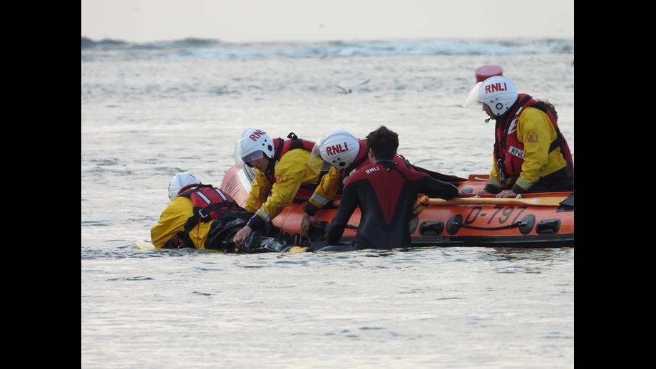 Wells Lifeguards join Wells RNLI D-class lifeboat on training exercise. Two lifeguards join a volunteer lifeboat crew of four on a training exercise. Lifeboat crew practising how to best mauver casualty onto lifeboat
