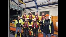 The eight new recruits dressed in full PPE standing next to the inshore rescue hovercraft