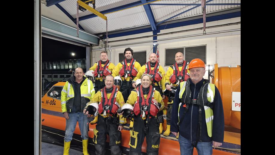 The eight new recruits dressed in full PPE standing next to the inshore rescue hovercraft