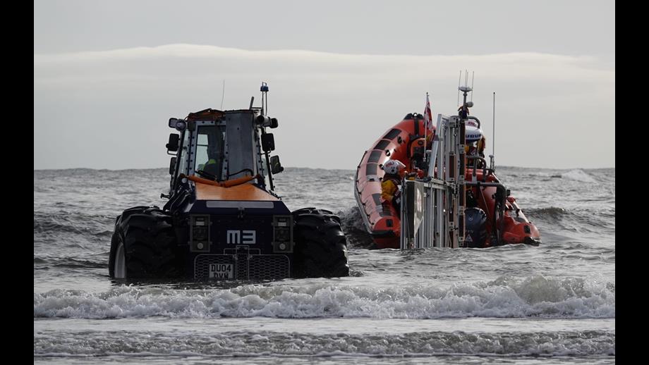 Tractor and lifeboat in swell close to shore