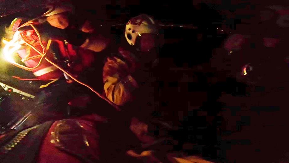 Volunteer crew member in ILB shining torches out to sea
