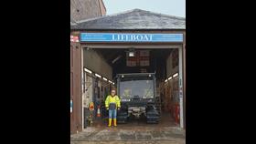 Peter Esson, new Lifeboat Operations Manager for Stonehaven RNLI stands at the entrance to the boat shed next to the tractor rig
